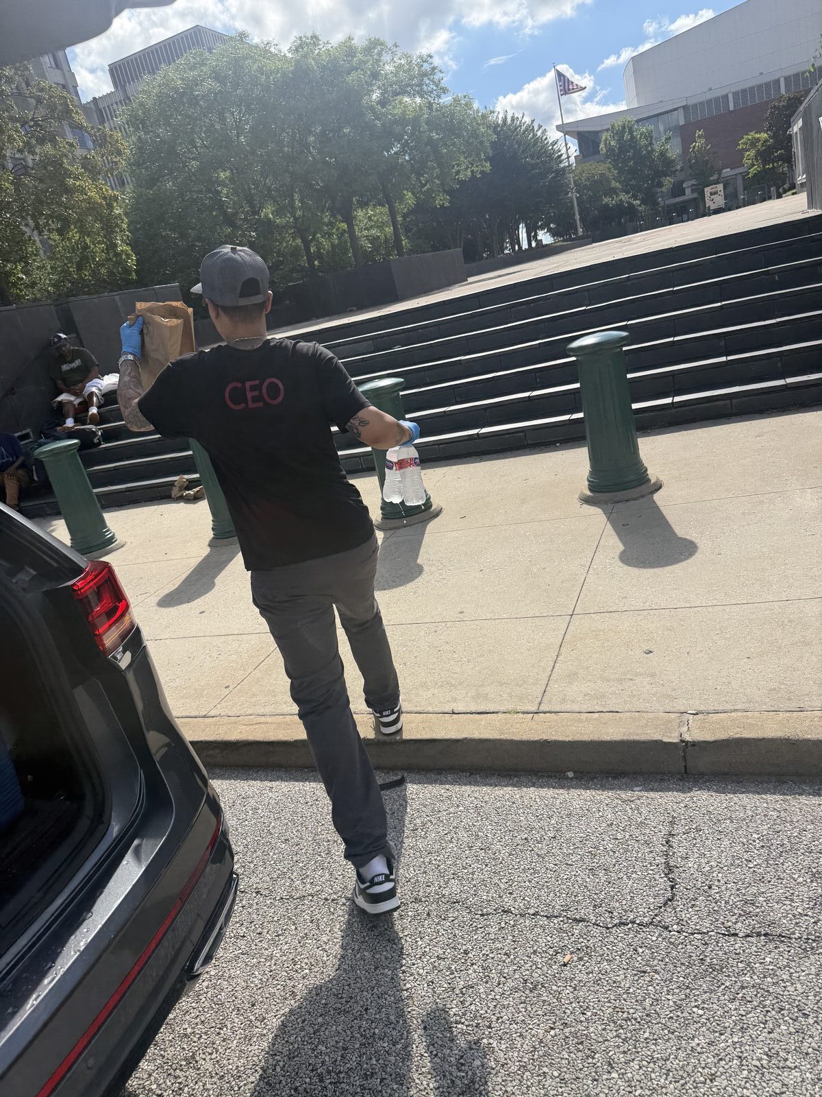 Team member carrying lunch bags up a set of steps during a delivery